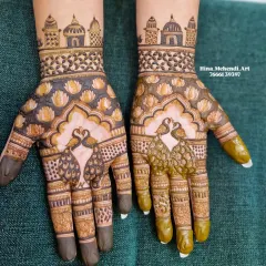 Another view of the peacock and temple design, showing the fresh henna paste on one hand and the semi-dry paste on the other.