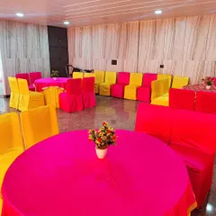 A simple and bright seating arrangement for a housewarming party or get-together. The use of vibrant pink and yellow fabric for the chairs and tables instantly makes the space feel festive.