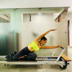 A beautiful demonstration of a side stretch on the Reformer. This movement lengthens the entire side of the body, improves flexibility, and strengthens the obliques.