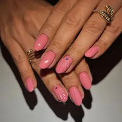 We gave this classic pink manicure a subtle artistic touch. The set features a lovely pink polish with two accent nails showcasing a delicate, 3D shell-like texture and a tiny purple stud for a hint of uniqueness.