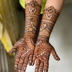 This engagement mehendi features bold, symmetrical patterns that extend up the arm. The design is intricate and makes a statement, perfect for celebrating this special occasion.