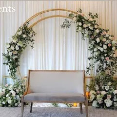 Clean, classic, and so romantic. This double-arch backdrop, adorned with lush white roses and greenery, creates an elegant and timeless focal point for an engagement ceremony or reception seating.