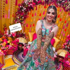 A radiant bride on her mehandi day. I love being part of these happy moments and creating designs that match the joy of the occasion, complete with a vibrant floral backdrop.