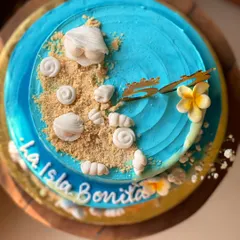 I brought beach vibes to a 50th birthday with this "La Isla Bonita" two-tier cake. The design features buttercream waves, edible sand, and handcrafted shells, showing how I can turn any idea into a delicious reality.
