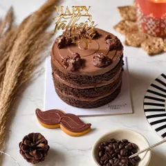 The Gentleman's Cake for Father's Day, a rich chocolate cake with a "Happy Father's Day" topper. Paired with a mustache-shaped cookie, it's a sophisticated treat for a deserving dad.