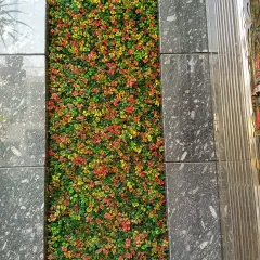 A different angle of the artificial plant floor inlay, showing how it adds an unexpected pop of color and nature to an indoor staircase landing.