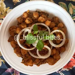 My street-style Chana Batata is a tangy and spicy chickpea and potato snack, garnished with fresh onion rings and mint.