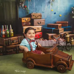 Let the adventures begin. This little explorer is ready for his journey in a vintage-themed studio setup. I provide a wide range of props like this wooden car and classic suitcases to create playful, imaginative portraits for your child.