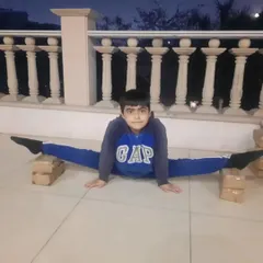 We use progressive methods to help kids achieve their flexibility goals safely. This student is working on his middle split, using stacked boxes for support to gradually deepen the stretch over time.