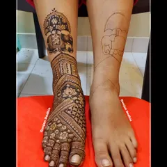 Here you can see the before and after of a bridal leg design. I started with a simple outline of an elephant under a decorative umbrella and then built up the intricate patterns around it, covering the entire foot with traditional motifs for a complete bridal look.