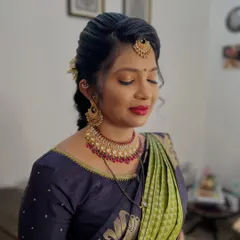 This look is all about traditional elegance. I created a soft makeup look with a classic red lip and paired it with a neat, braided hairstyle, perfect for any South Indian wedding function.
