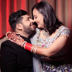A joyful, candid moment from a Roka ceremony. The couple is sharing a laugh and a close embrace, their happiness evident. This photo captures the fun, celebratory atmosphere of pre-wedding events and the genuine connection between the couple.