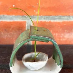 This unique ikebana-style vase was hand-built by a student. The arched form creates a beautiful frame for a single stem.