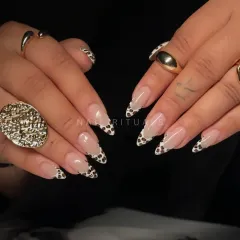 A modern twist on a classic. These almond-shaped nail extensions feature a chic cow print design on the French tips, giving a playful yet sophisticated finish to a nude manicure.