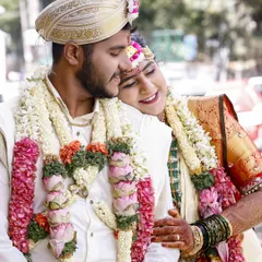 A tender moment between the bride and groom during their South Indian wedding ceremony. The bride rests her head on his shoulder, a quiet moment of comfort and love.