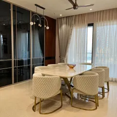 This dining space combines elegance with modern design. We paired a sleek marble tabletop with quilted cream chairs and brass accents, while the smoked glass wardrobe provides a reflective, space-enhancing backdrop.