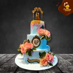 For this three-tier engagement cake, I used a soft blue buttercream and adorned it with fresh peach roses and a custom monogram. The gold drip and elegant topper add a touch of luxury to celebrate the couple's new beginning.
