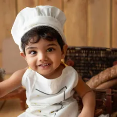 A close-up of my little chef. His happy expression and the adorable uniform make this a picture-perfect moment.