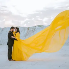 A wide shot showing the full sweep of the yellow gown against the unique, almost snowy terrain of Kishangarh. This location offers a one-of-a-kind backdrop for a pre-wedding shoot.