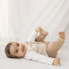 A simple and sweet portrait. This six-month-old, lying on a clean white backdrop, shows off his happy and relaxed personality.