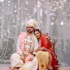 A serene portrait of the couple amidst a rain of flowers, capturing a moment of peace during the vibrant ceremony.