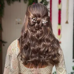 This half-up hairstyle is one of my most requested looks for engagements and pre-wedding events. I crafted a delicate bow with the hair itself and added leafy silver accessories and scattered pearls through the soft waves for a touch of fairytale romance.