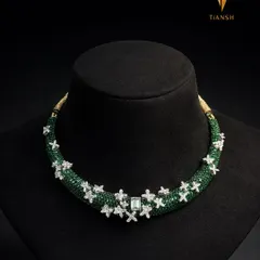 A studio shot of the finished refurbished hasli. The vibrant green stones contrast beautifully with the sparkling diamonds, creating a statement piece that is both modern and timeless.