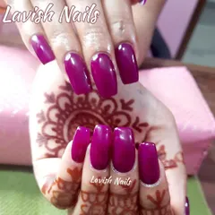 Bold, glossy magenta nails in a square shape provide a stunning pop of color that enhances the beauty of traditional mehendi patterns.