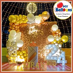 A glamorous 24th birthday celebration with an outdoor setup. The decor features a gold sequin wall, a 'Happy Birthday' neon sign, and a gold and white balloon arch.