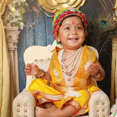 A happy little Kanha sitting on his throne. The rich, golden set with peacock feathers and intricate details creates a truly divine atmosphere for these special cultural portraits.