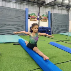 Every champion was once a beginner. Here, a young gymnast shows amazing flexibility and balance, practicing her splits on our professional-grade padded beam. We help kids safely push their limits and discover what their bodies can do.