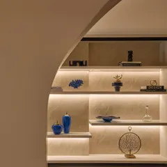 An identical shot of the foyer shelving, seen through an archway. This view highlights how the lighting and color choices create an immediate sense of atmosphere and intrigue.