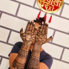 This full-arm bridal mehendi is perfect for a grand celebration. The dense patterns include traditional checks, floral bands, and hidden initials for a personal touch.