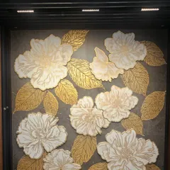 Poetry on stone. This panel features 3D flowers with gold-leafed leaves on a dark stone base, creating a luxurious and artistic statement.