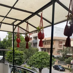 My red hanging planters looking vibrant on a customer's balcony. It's so rewarding to see my products bringing color and life to your spaces.
