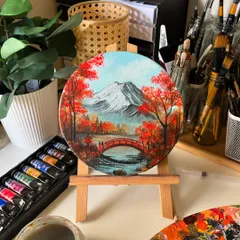 The finished round canvas painting of Mt. Fuji, displayed on a mini easel in my studio. The colors are so vibrant and warm.