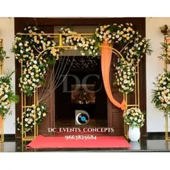 A sophisticated wedding entrance with a gold metal frame adorned with white flowers and soft peach draping. This modern and elegant design creates a beautiful welcome for guests.