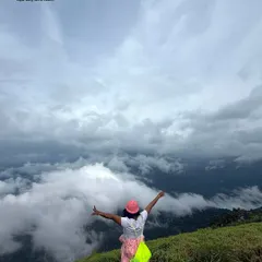 A moment of pure freedom. A trekker with arms outstretched, embracing the cloudy sky on an Independence Day adventure.