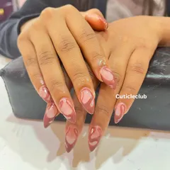 A trendy and chic design with a brown abstract swirl pattern on almond-shaped nails. This is a great example of a modern, minimalist art style.