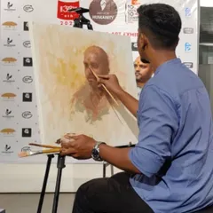 Working on a live portrait at the Kamalnayan Bajaj Art Gallery. This image captures a moment of intense focus as I use a fine brush to render the details of the subject's face.