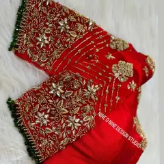 A masterpiece for our bride Madhuri. This classic red bridal blouse is heavily embroidered with zardosi and stone work, featuring a beautiful heart-shaped cutout on the back. The sleeves are a canvas of intricate floral patterns, making it a truly royal piece.
