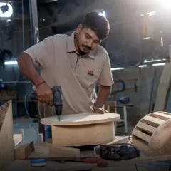 An artisan at work, assembling a custom piece with precision. This image captures the dedication and skill that goes into every joint and angle, ensuring our furniture is built to last for generations.