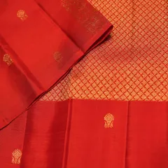 The body of the red Kanjivaram features a diamond-patterned brocade with delicate buttas, creating a rich and textured look.