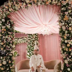 The groom awaits his bride in a mandap overflowing with romance. We used a canopy of blush pink and white flowers with a delicate draped ceiling to create an intimate and elegant space for Sakshi and Shuvam's ceremony.