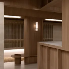 Another perspective of the interior at Be Well, highlighting the interplay of volumes and surfaces. The design avoids ornamentation, focusing instead on the inherent beauty of the wood and stone.