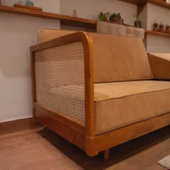 Here is a detail of my sofa's construction. The robust teak wood frame is complemented by woven rattan panels on the sides, a signature combination that ensures both durability and refined style.