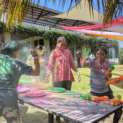 The joy of Holi is universal. Here, our co-farmers enjoy a playful moment with water guns, surrounded by the green expanse of Maamara farm.