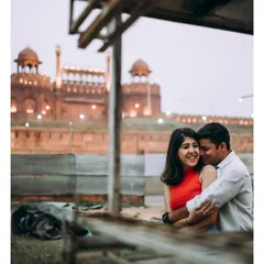 A warm embrace with the iconic Red Fort in the background. This photo blends a personal, loving moment with a landmark of Delhi.