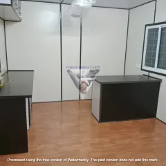 This is the interior of a typical portable office cabin I deliver. It’s a clean, functional space with wood-finish flooring, multiple windows for natural light, and pre-installed electrical points. I’ve set this one up with a reception desk and a work counter.