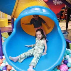 Nothing beats the thrill of the slide! This happy girl is about to make a splash in our massive ball pit, a favorite spot for kids of all ages.